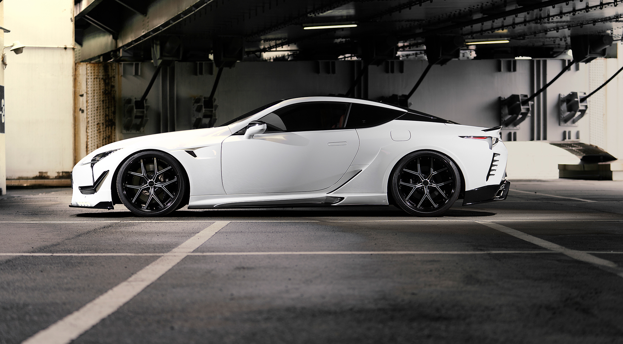 Side profile of a white Lexus LC on 21 inch ILLIMA I 12F forged wheels in Black Polish
