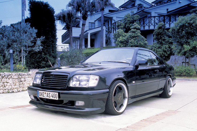 Black Mercedes-Benz E-Class Coupe C124 WALD V4 front view on a resort driveway