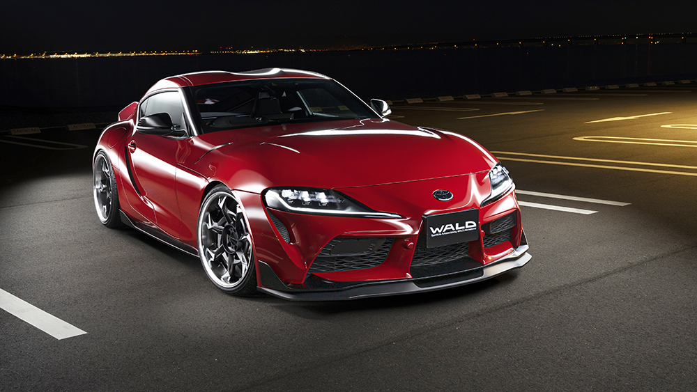 Red WALD Sports Line Toyota Supra DB## front three-quarter view showing the front lip spoiler at night