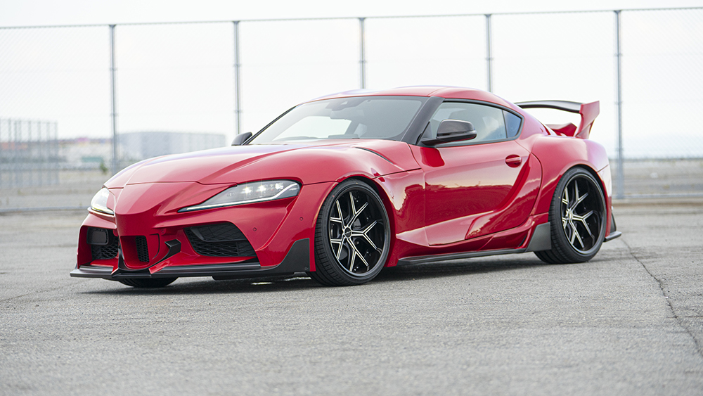 Red WALD wide body Toyota Supra front three-quarter view showing widened front fenders and side skirt detail