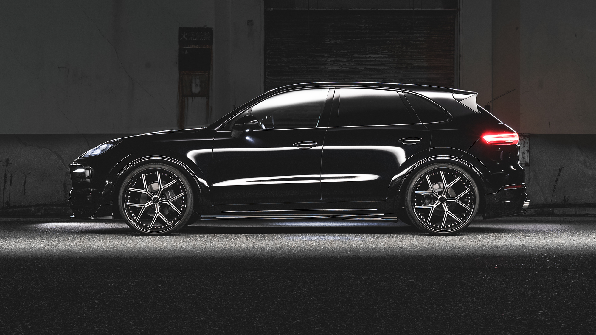 Side profile of a black Porsche Cayenne fitted with WALD ILLIMA I13F 24 inch forged wheels