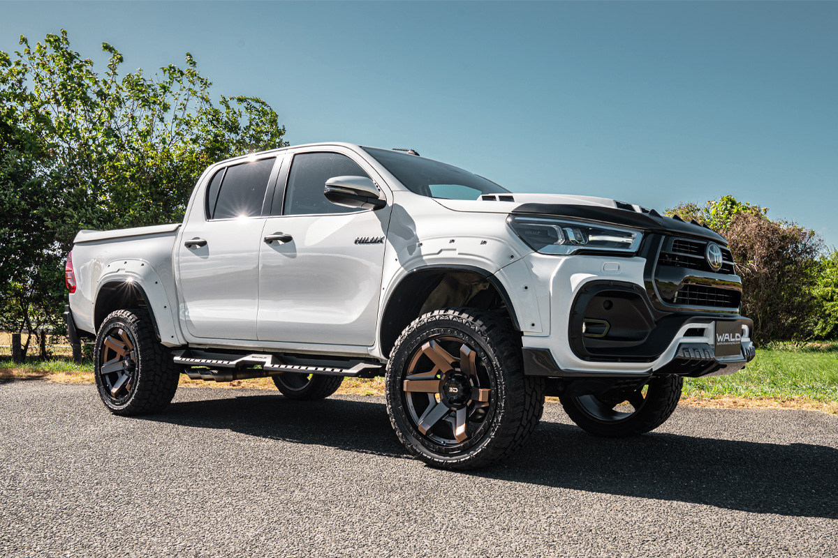 White Toyota Hilux double cab with WALD arch extensions on DS001 Matte Bronze Black wheels