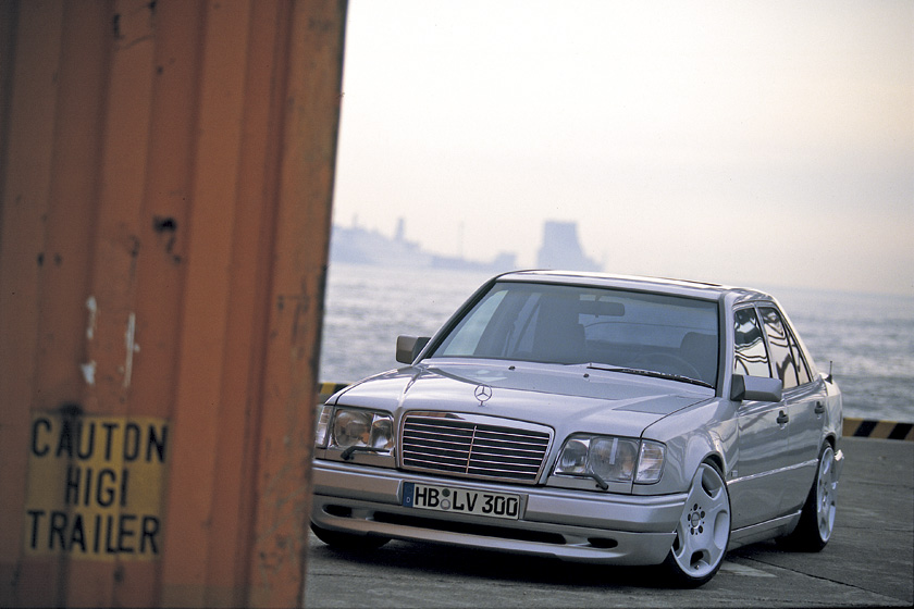 Silver Mercedes-Benz E-Class W124 WALD Executive Line front three-quarter view on a dockside