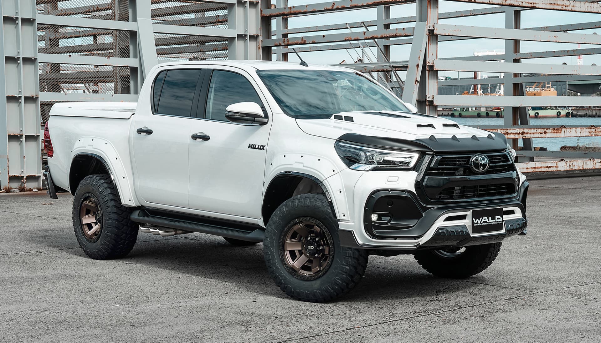 White Toyota Hilux with WALD front bumper and bonnet on DS001 wheels with mud-terrain tyres