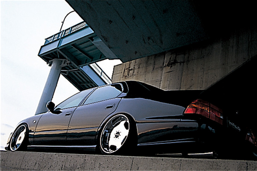 WALD Executive Line V3 Toyota Celsior UCF20/21 — low rear three-quarter view beneath a bridge with WALD side skirt and rear skirt