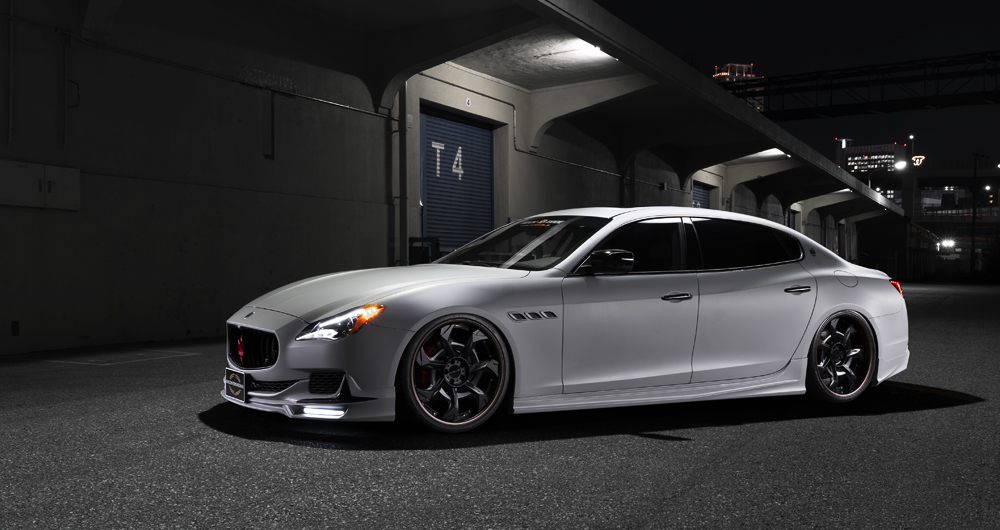 Matte grey WALD Maserati Quattroporte side profile with WALD side skirts under city overpass
