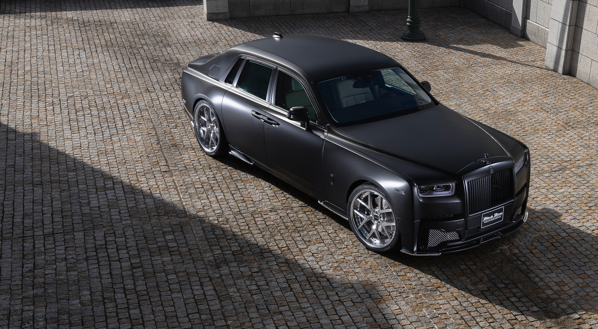 Rolls-Royce Phantom 8 WALD Black Bison Edition — elevated front three-quarter view on cobbled courtyard