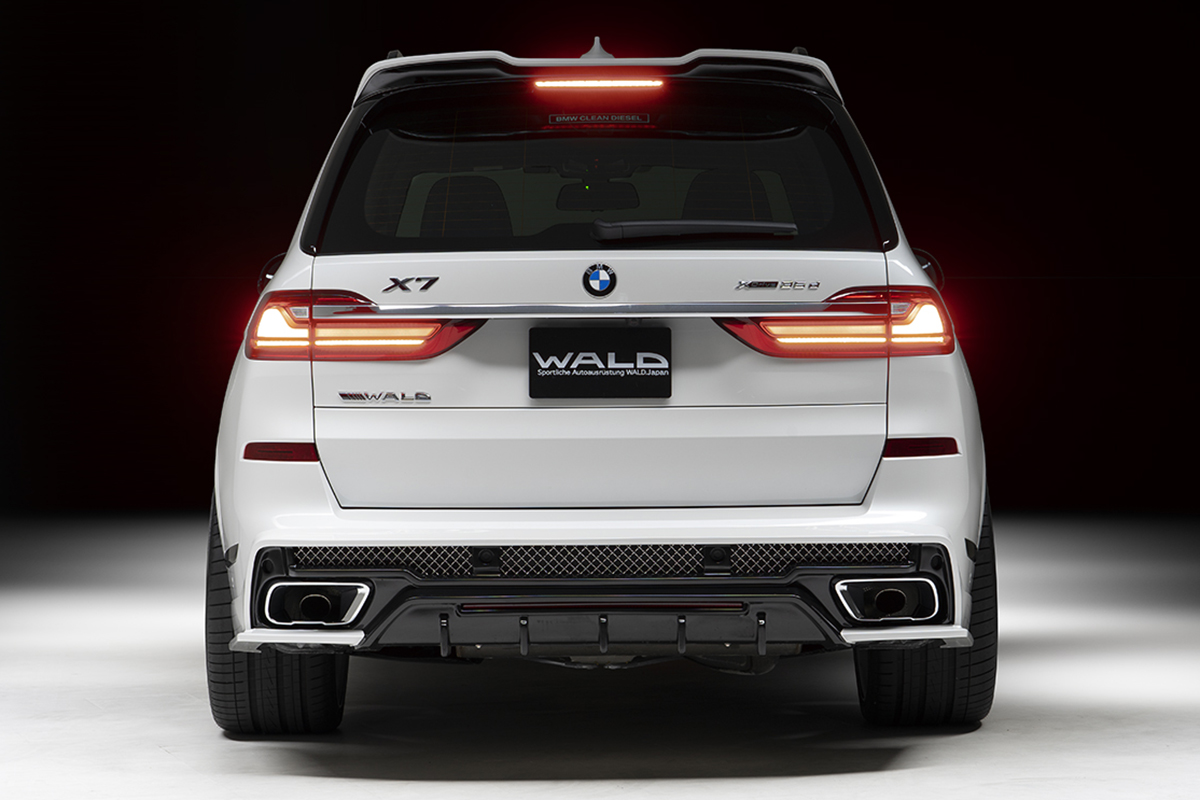 WALD BMW X7 G07 direct rear view with WALD rear skirt, intake net and illuminated LED lamps