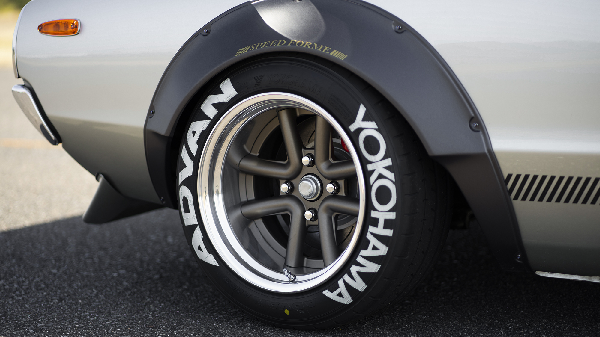Rear wheel and arch detail of a classic Nissan on WALD Octopus Racing wheels