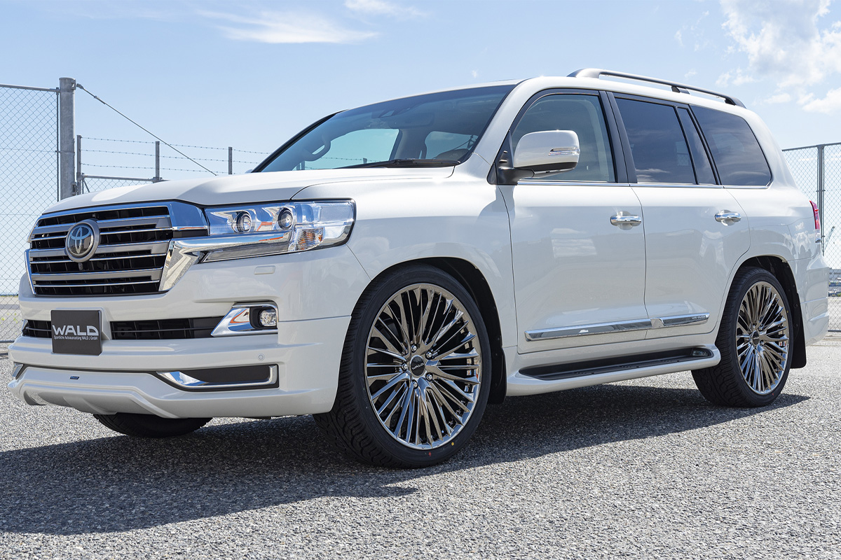 White Toyota Land Cruiser 200 fitted with WALD Genuine Line F-001 wheels in SBC Super Black Coat, front three-quarter view