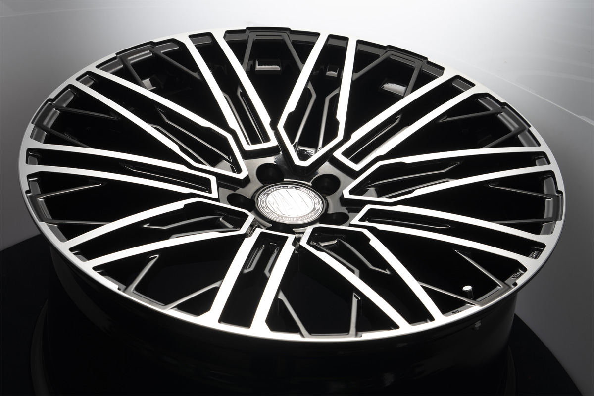 WALD Genuine Line BM001 wheel in Black Polish photographed against a light gradient background