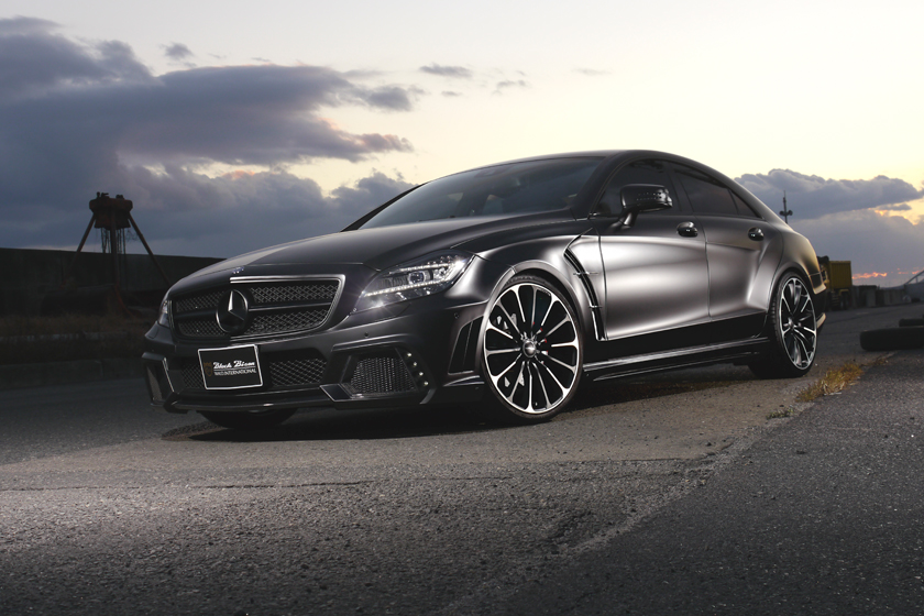 WALD Black Bison Mercedes-Benz CLS C218 front three-quarter view at dusk with WALD full body kit and multi-spoke wheels