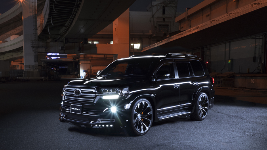 WALD Sports Line Toyota Land Cruiser 200 URJ202W in black at night with wide arch package, LED lamps and JARRET monoblock wheels