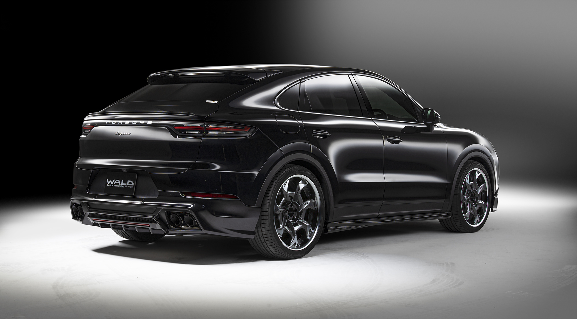 WALD Porsche Cayenne Coupe rear skirt — black Cayenne Coupe 9YA rear three-quarter view with WALD rear skirt and quad exhaust tips