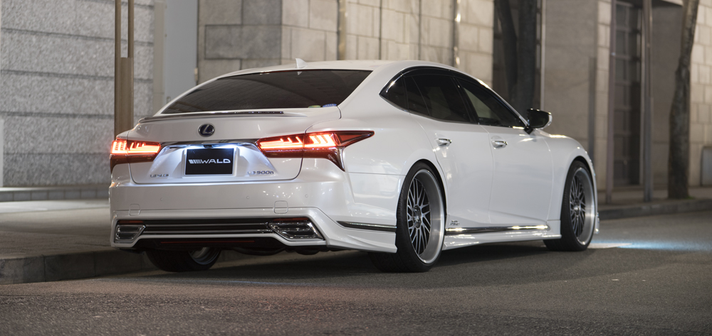 WALD Lexus LS500h rear view in white at night with WALD number plate, rear skirt and chrome tail finishers