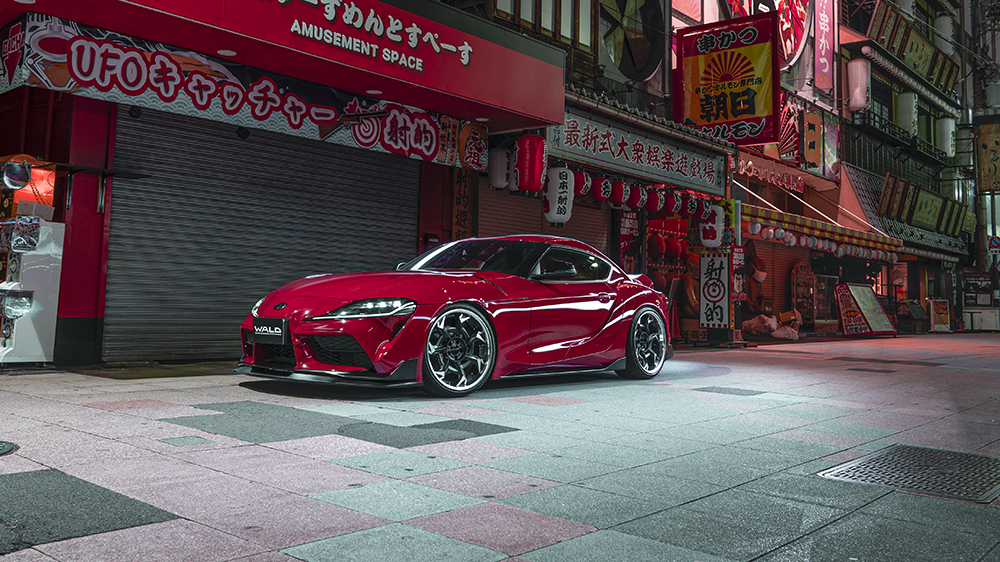 Red WALD Sports Line Toyota Supra DB## on a Japanese street at night with front lip spoiler