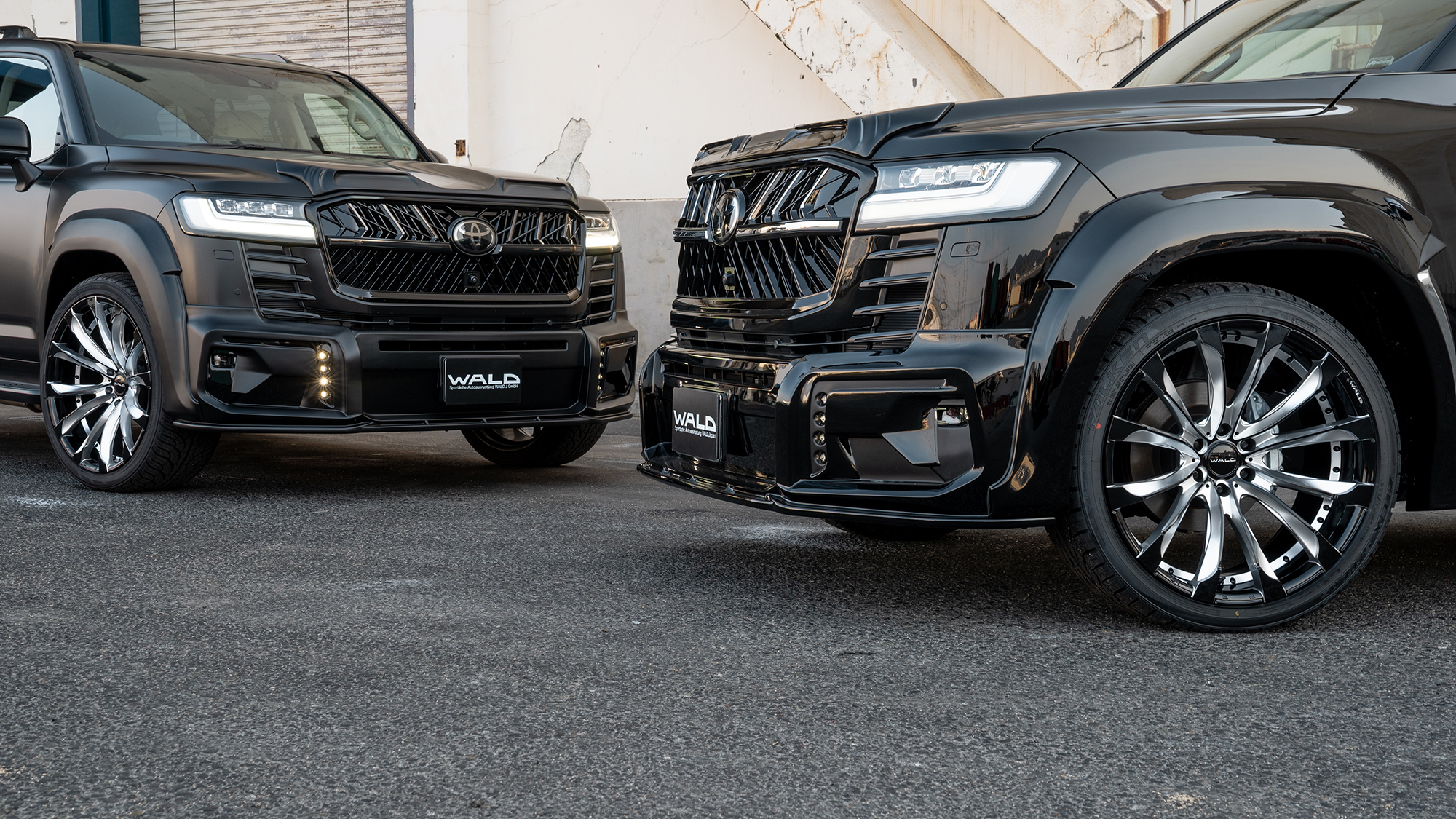 Two WALD Black Bison Land Cruiser 300 ZX conversions side by side showing front spoiler variations