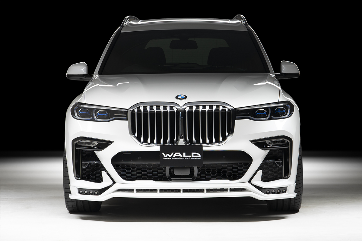 WALD BMW X7 G07 head-on front view showing WALD front spoiler with LED lamps and mesh net