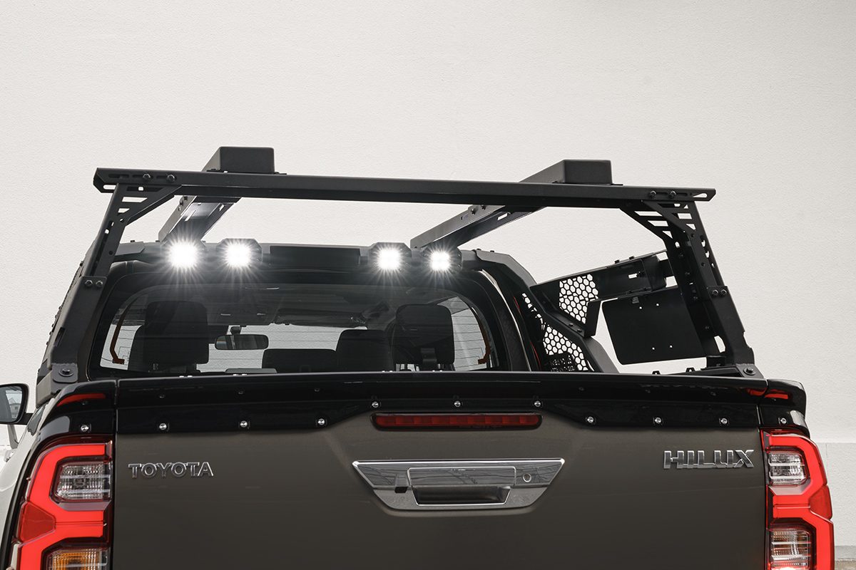 Rear view of the WALD Toyota Hilux GUN125 facelift bed rack with LED lamps illuminated above the tailgate