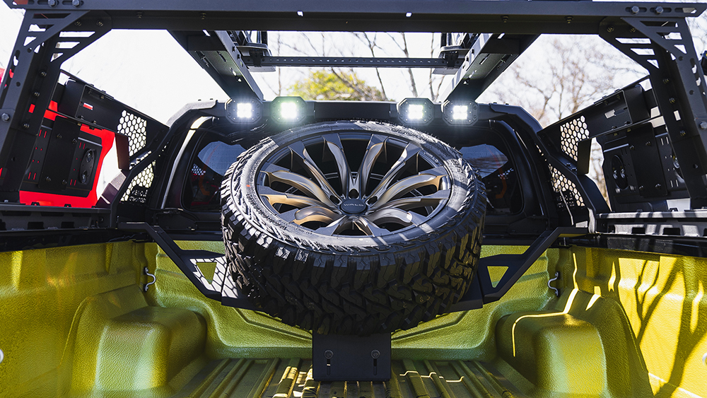 Bed-level view of the WALD Black Bison spare tyre hanger, roll bar LED lamps and storage panels