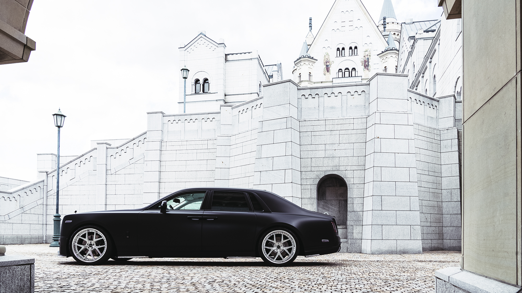 Side profile of a matte black Rolls-Royce Phantom on WALD ILLIMA I13F 24 inch 3-piece forged wheels