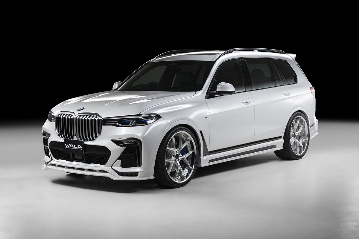 WALD BMW X7 G07 Sports Line front three-quarter studio view with rear roof spoiler fitted