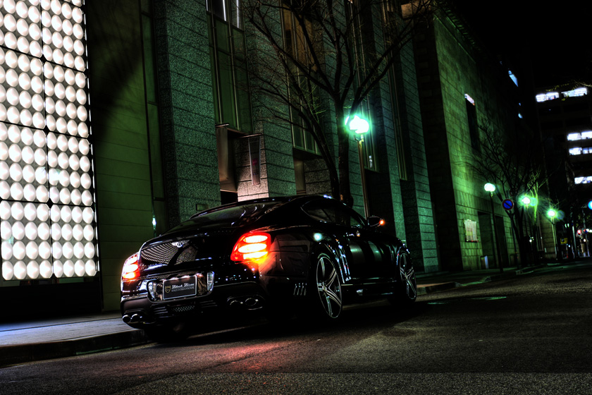 Rear three-quarter night shot of a Bentley Continental GT WALD Black Bison on MAHORA M11C wheels