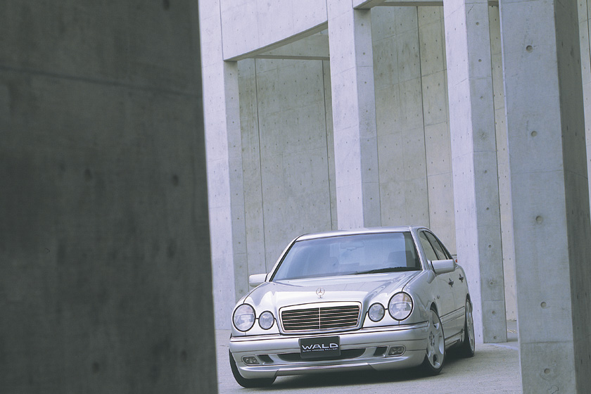 Mercedes-Benz E-Class W210 WALD Executive Line framed by concrete columns