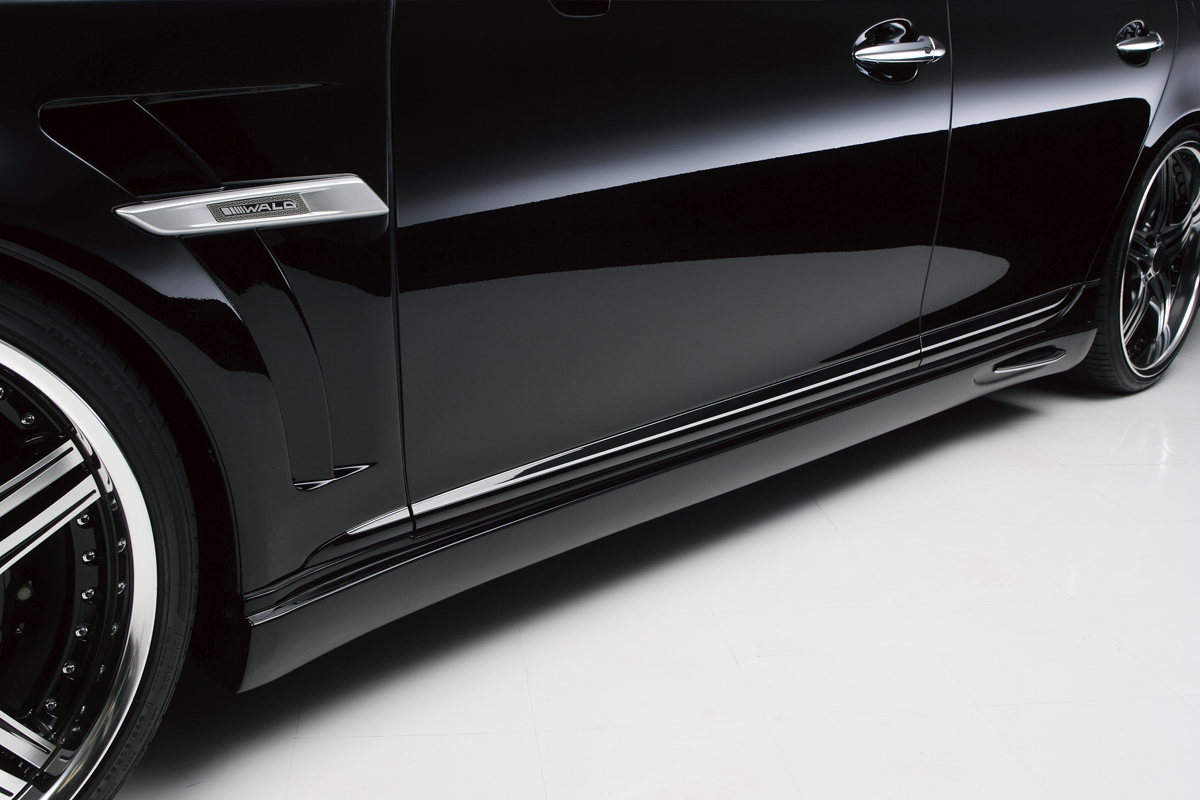 WALD Lexus LS600h side skirt detail in gloss black with chrome fin cover and WALD plate on the sport fender duct
