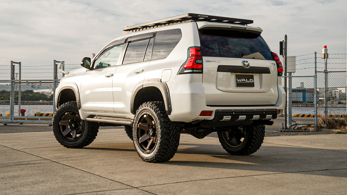 WALD Desert Line Toyota Land Cruiser Prado rear three-quarter view on location with roof rack, fender trim and bronze WALD wheels