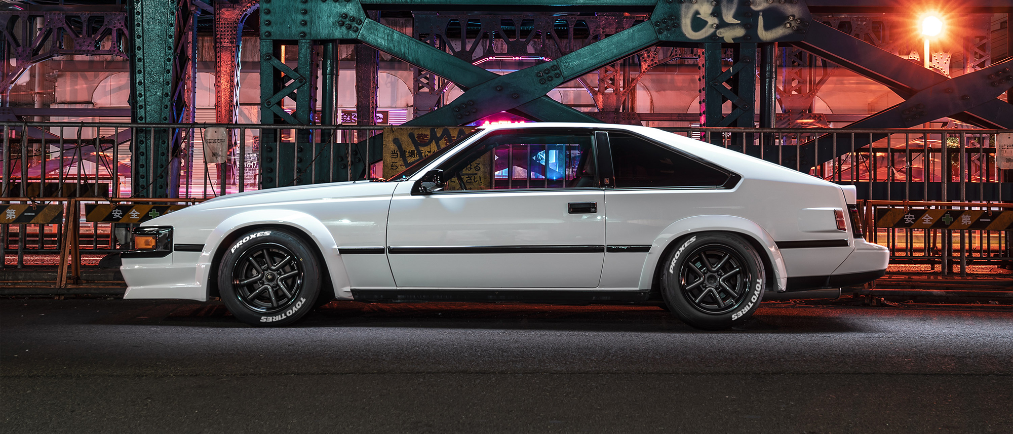 White Toyota Celica Supra A60 at night on WALD Octopus Racing wheels