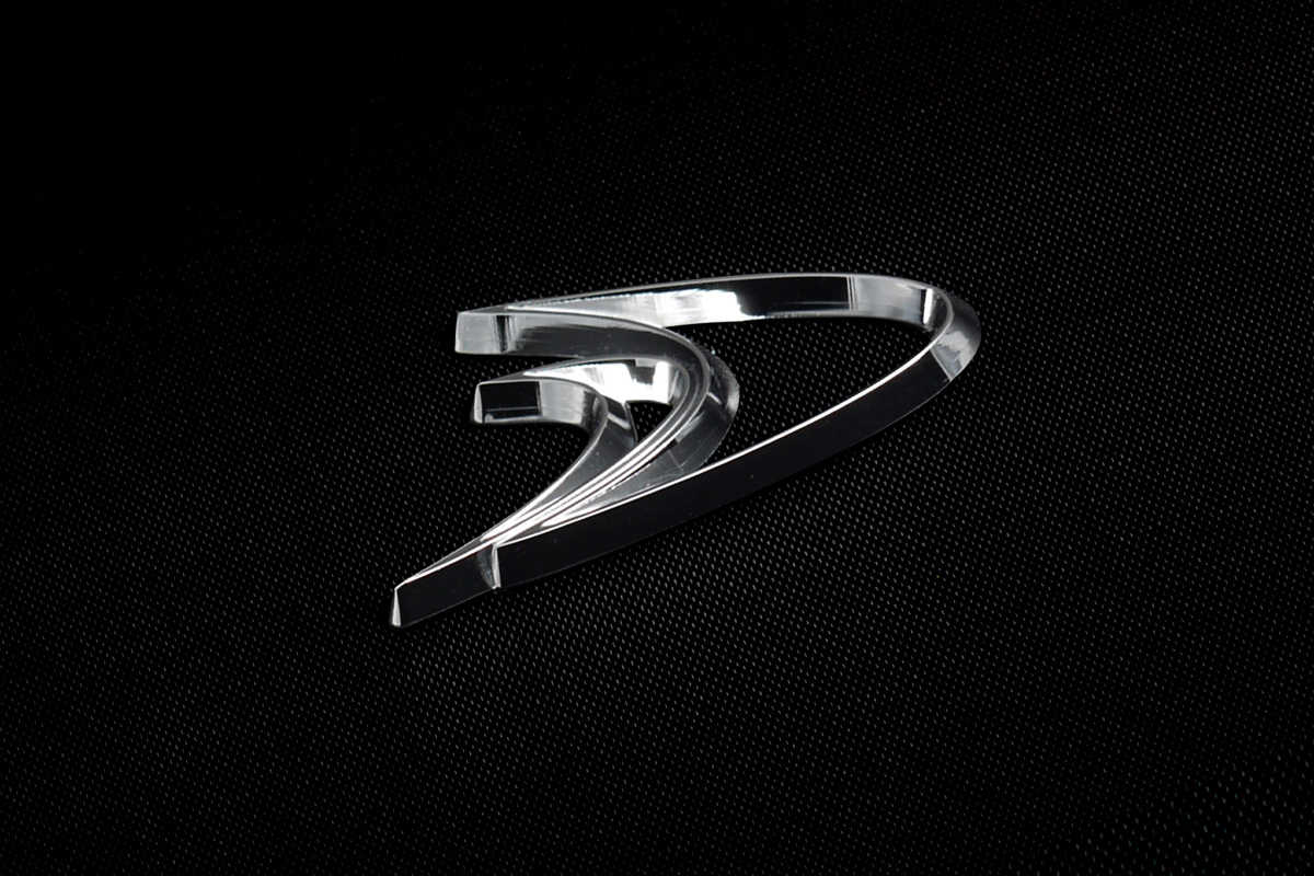 WALD W Arrow Emblem, a sculpted polished chrome arrow motif photographed on a black textured surface