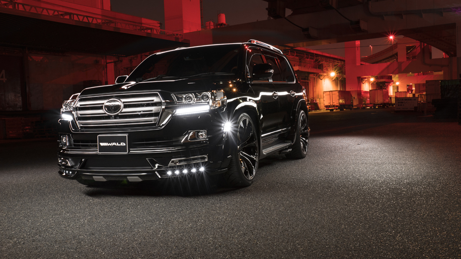 WALD Sports Line Toyota Land Cruiser 200 URJ202W black front three-quarter at night with illuminated front spoiler LED lamps
