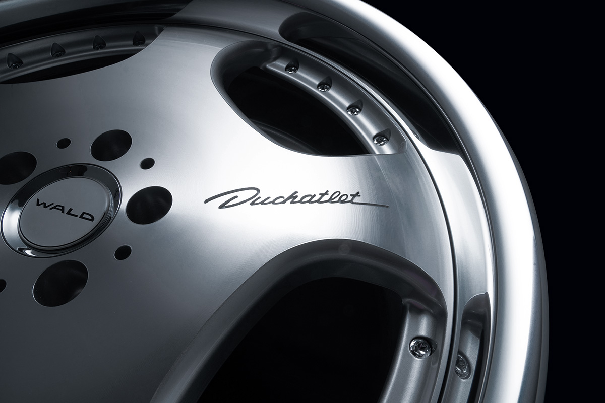 Close detail of the Duchatlet script and pin-bolt rim fixings on the WALD D22C wheel