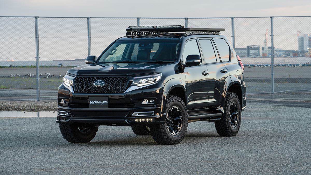 WALD Black Bison Edition Prado 150 in black with lift-up suspension springs and wide arch package, front three-quarter view