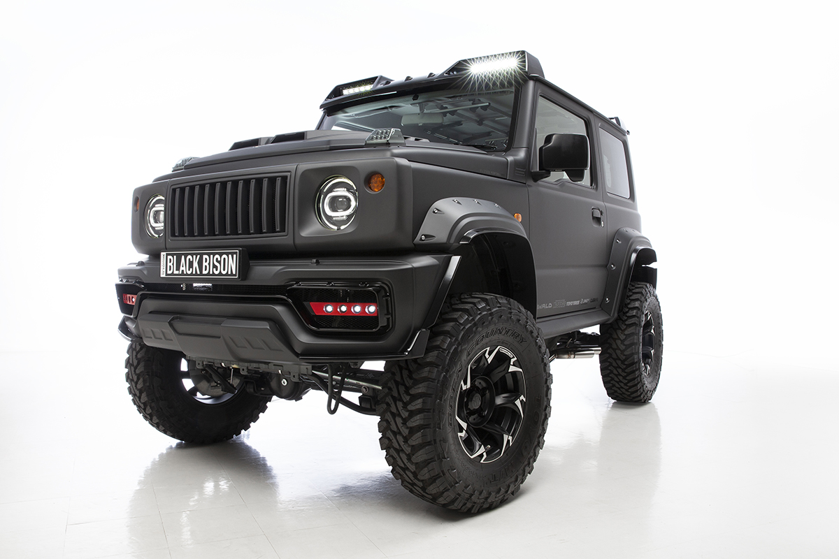 WALD Black Bison Edition Suzuki Jimny Sierra JB74W — matte black wide body Jimny front three-quarter studio view with Black Bison plate, Japamericana grill and roof LED light bars