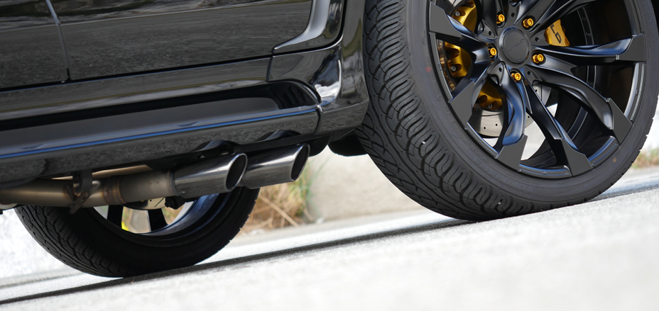 WALD Lexus LX570 rear exhaust and black wheel detail with yellow upgrade brake calipers
