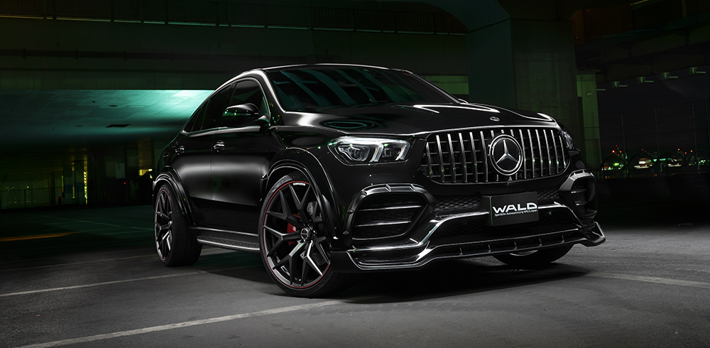 WALD Black Bison Mercedes GLE Coupe C167 AMG Line front three-quarter view at night with wide arch package and Panamericana grille