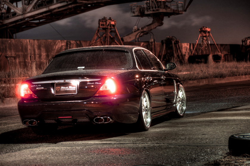 WALD Jaguar XJ X350 X358 conversion at night — rear three-quarter view with lights on