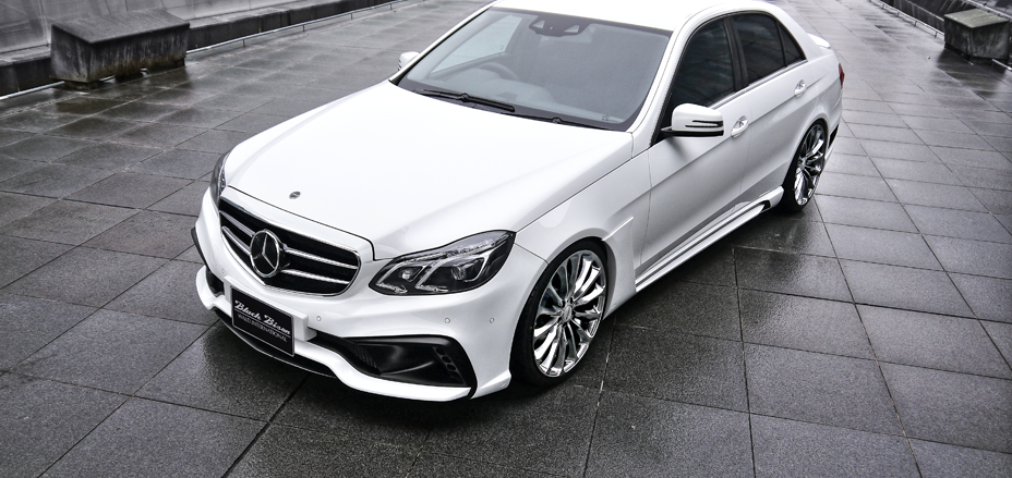 WALD Black Bison Mercedes-Benz E-Class W212 elevated front three-quarter view with front bumper spoiler and side skirts