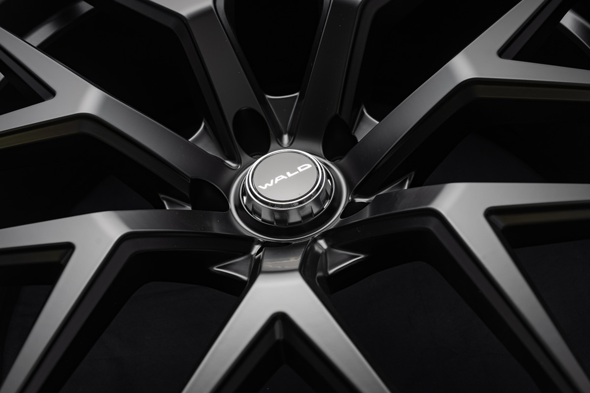 Macro detail of the WALD MB001 centre cap and spoke intersections on the 24 inch forged wheel