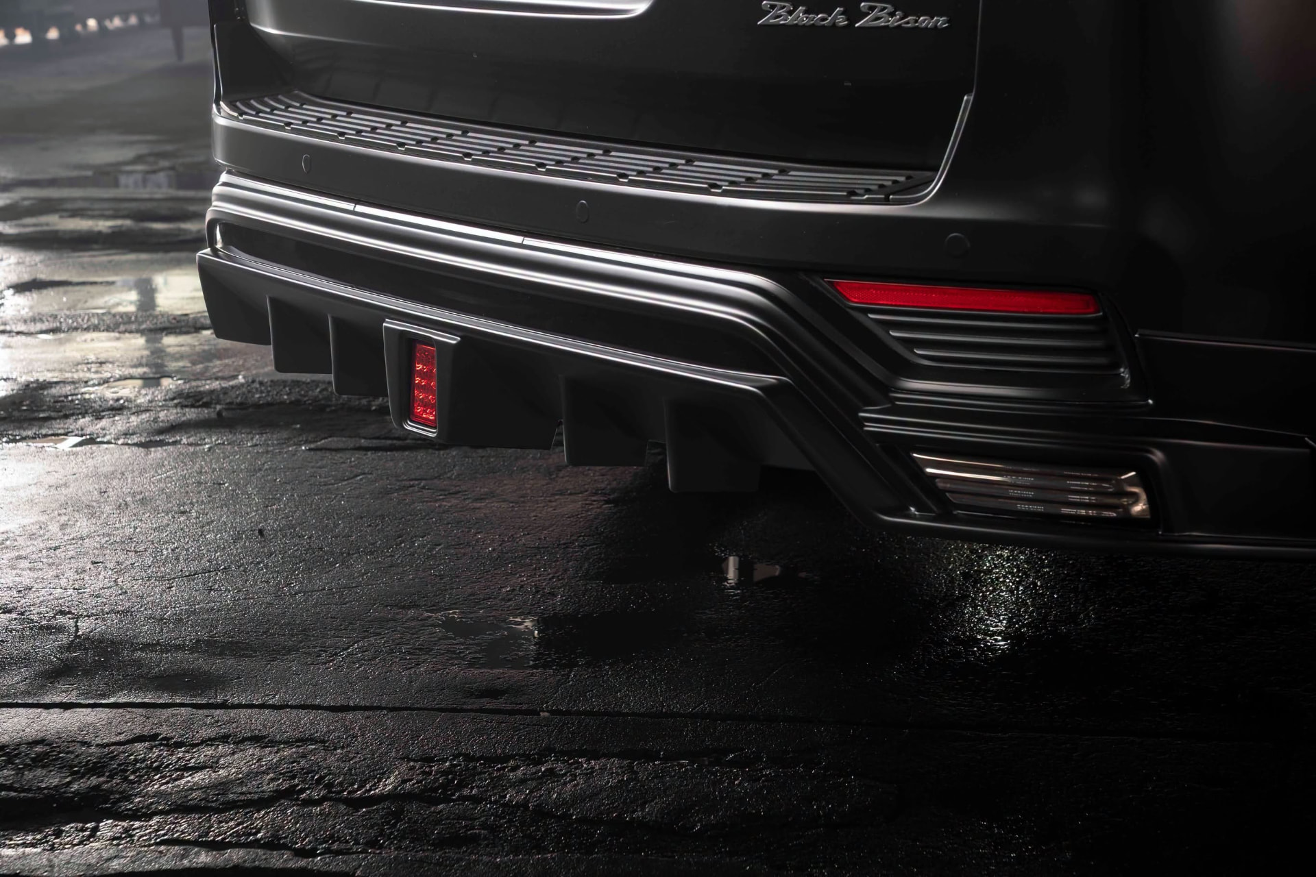 WALD Black Bison Land Cruiser 300 ZX rear skirt diffuser detail with LED rear fog lamp and Black Bison emblem