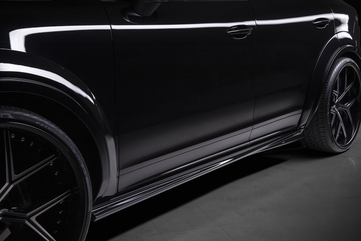WALD Porsche Cayenne side skirt detail — WALD Black Bison side skirt along the sill of a black Cayenne 9YA