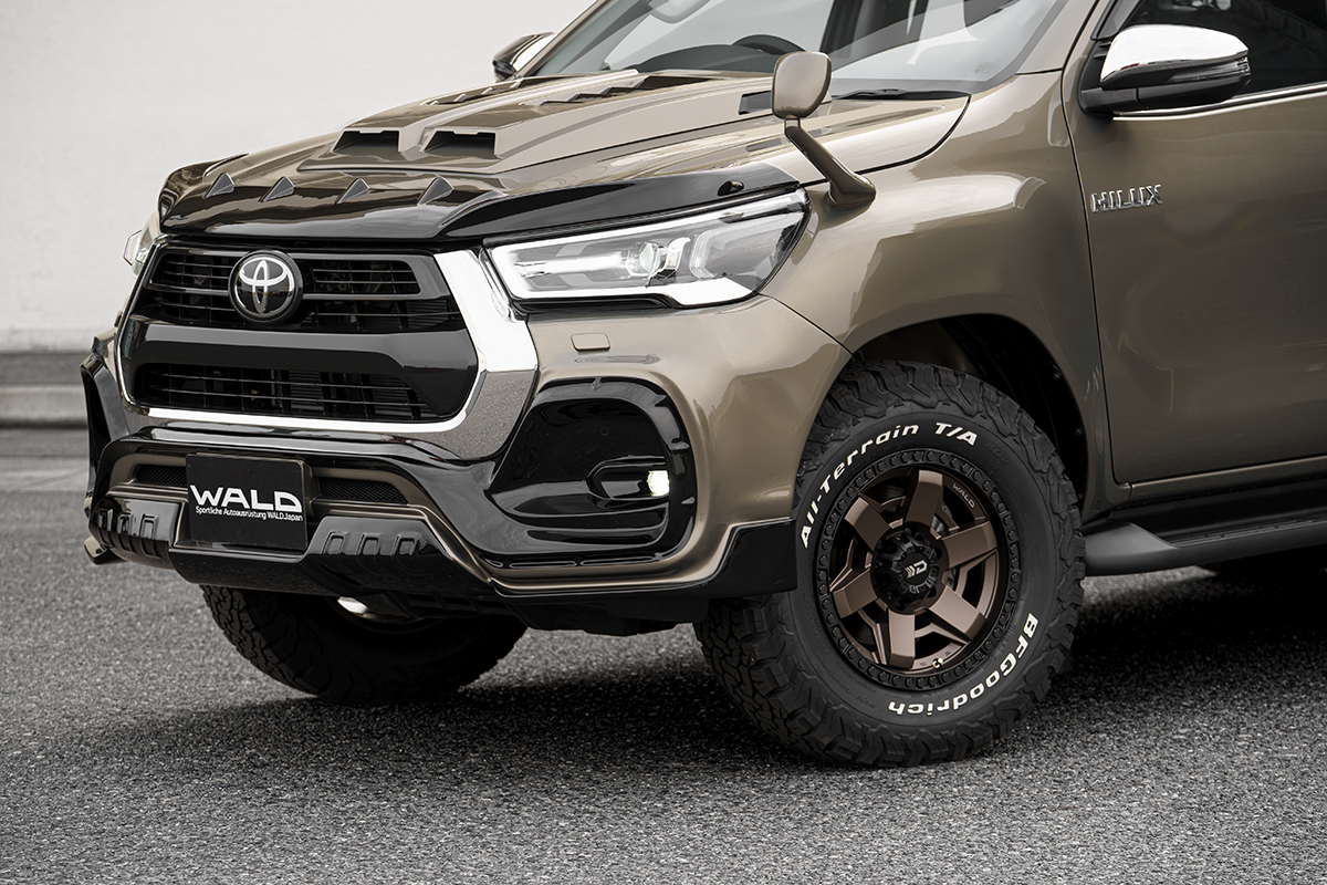 Detail of the WALD full-bumper front spoiler and bronze WALD wheel on the Toyota Hilux GUN125 facelift
