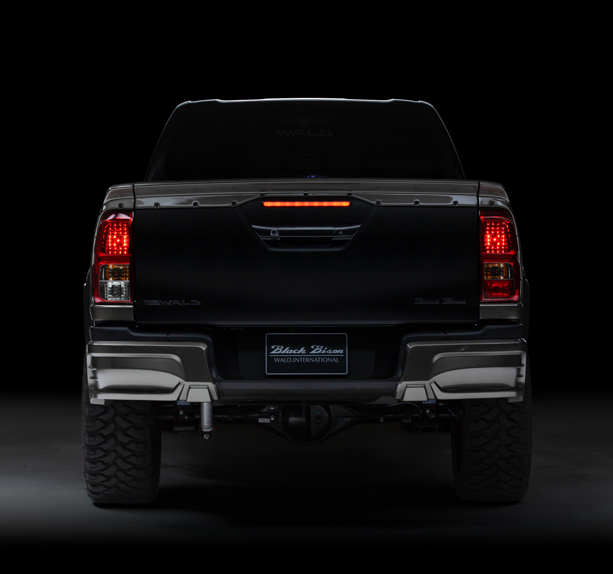 WALD Black Bison Toyota Hilux GUN125 rear view showing tailgate spoiler and rear spats with lighting illuminated