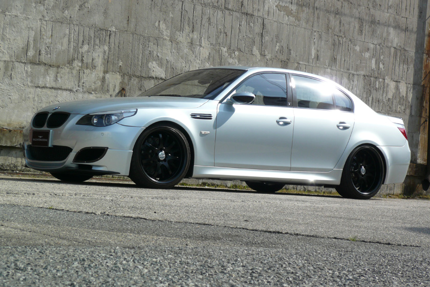 WALD BMW E60 M5 body kit side view on location with black WALD wheels