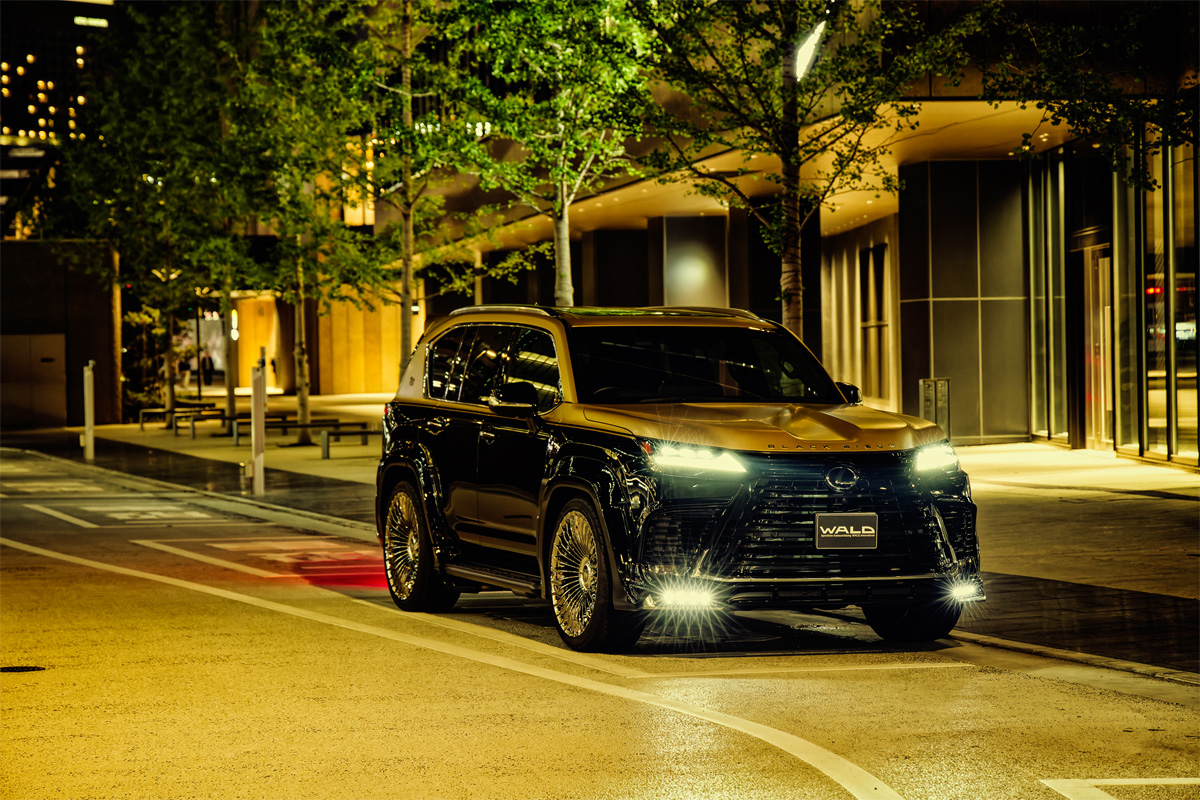 WALD Lexus LX600 Black Bison at night — illuminated front spoiler LED lamps and plated garnish set on a city street