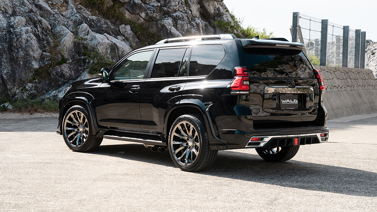 WALD Black Bison Edition Prado 150 rear three-quarter view on location with rear bumper spoiler, chrome garnish and side exit exhaust