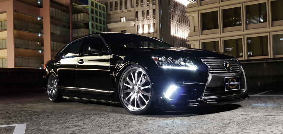 WALD Executive Line Lexus LS460L in black on a rooftop car park at night with WALD front spoiler on polished wheels