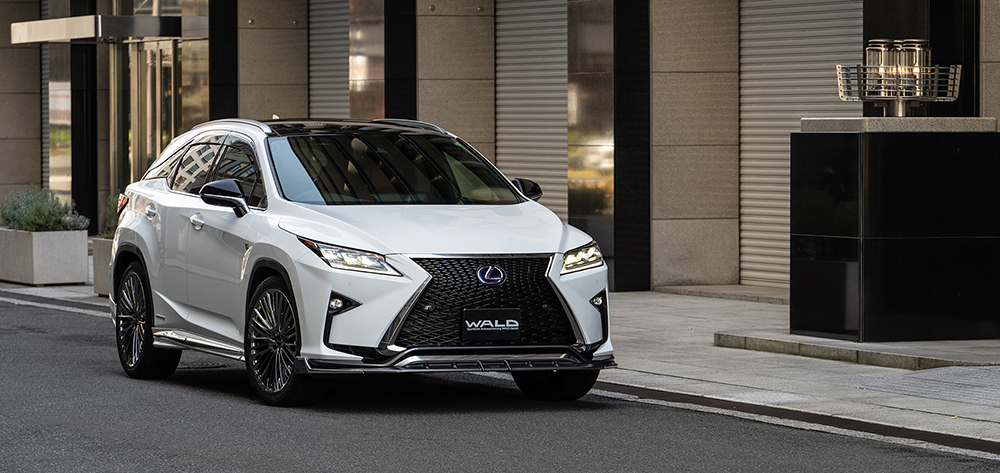 White WALD Lexus RX450h F SPORT front view with WALD front spoiler and lit headlights